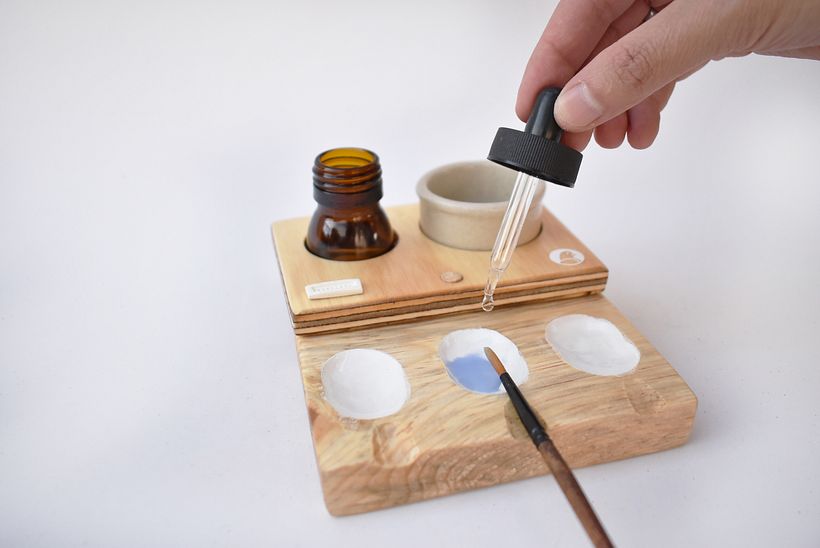 Tiene una bandeja de paleta mezcladora con estanques para mezclas y descansa pinceles.