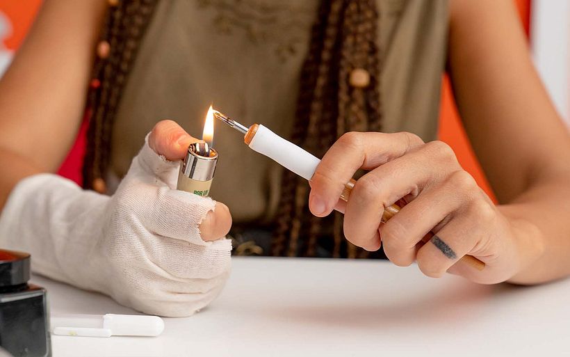 Natalia removes any grease or dirt from the steel nib before drawing.