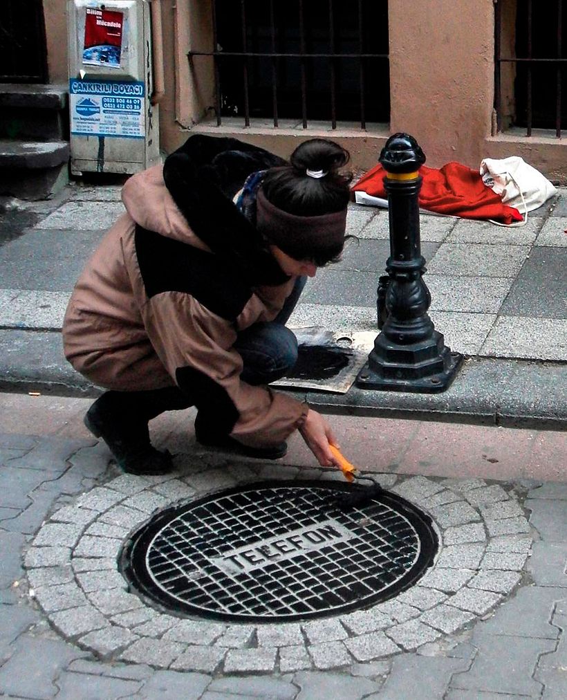 Raubdruckerin streicht den Deckel mit Farbe ein