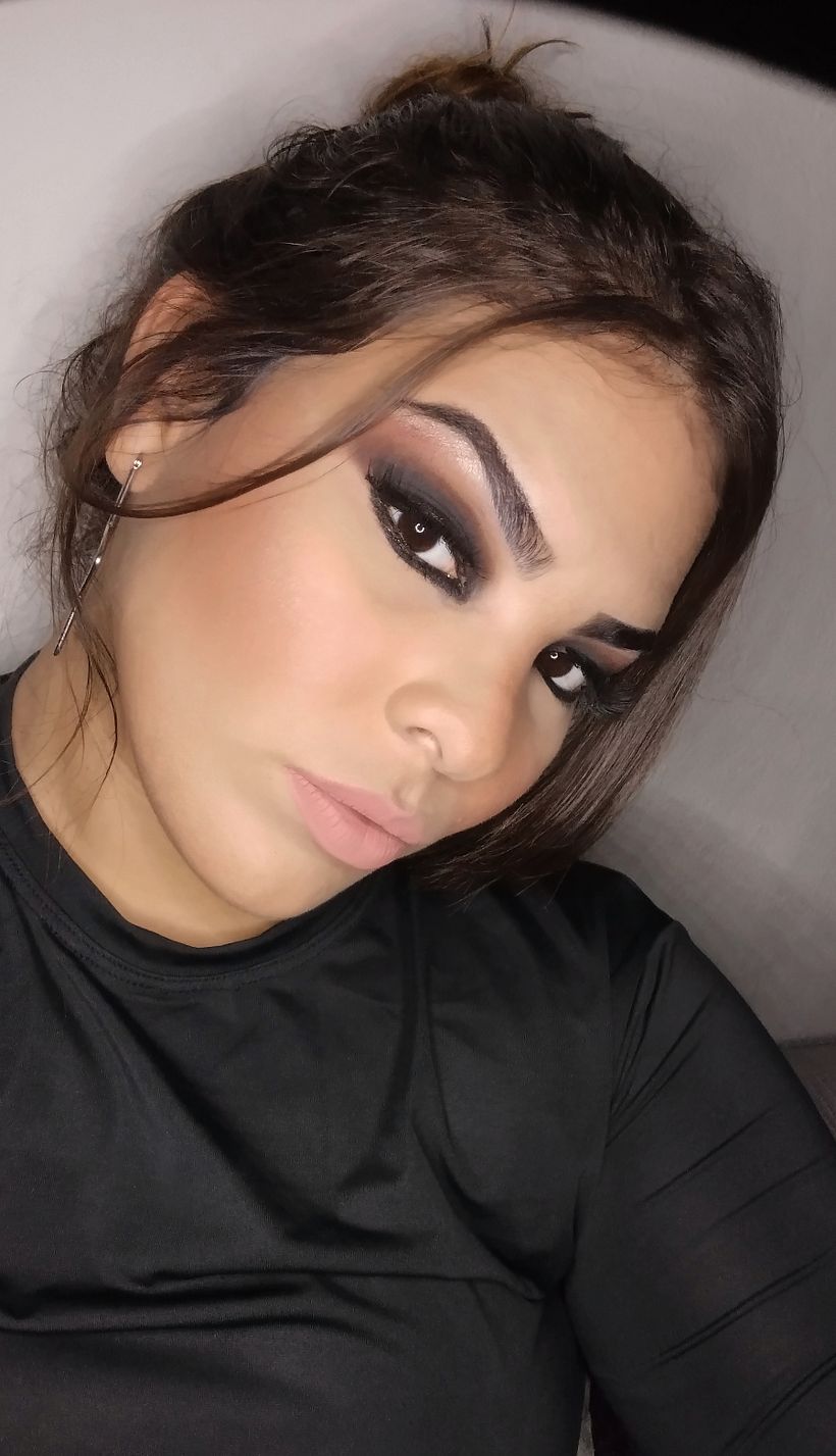 Aqui está a maquiagem de um look glamouroso, sendo composta por um olhão preto esfumado com um degradê terroso e boca nude