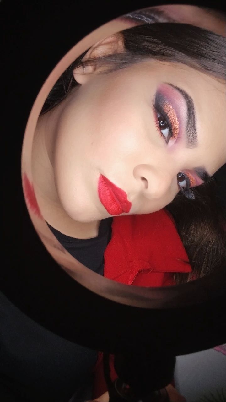 Essa é a maquiagem moderna, colorida, contando com um belo cut crease, degradês, sombra cintilante, cílios e bocão vermelho.