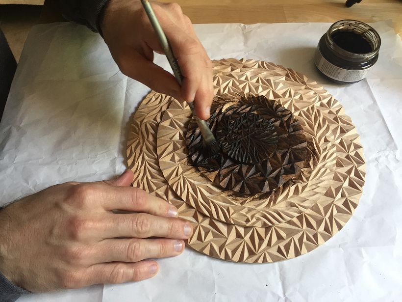 Applying dark stain with a brush.