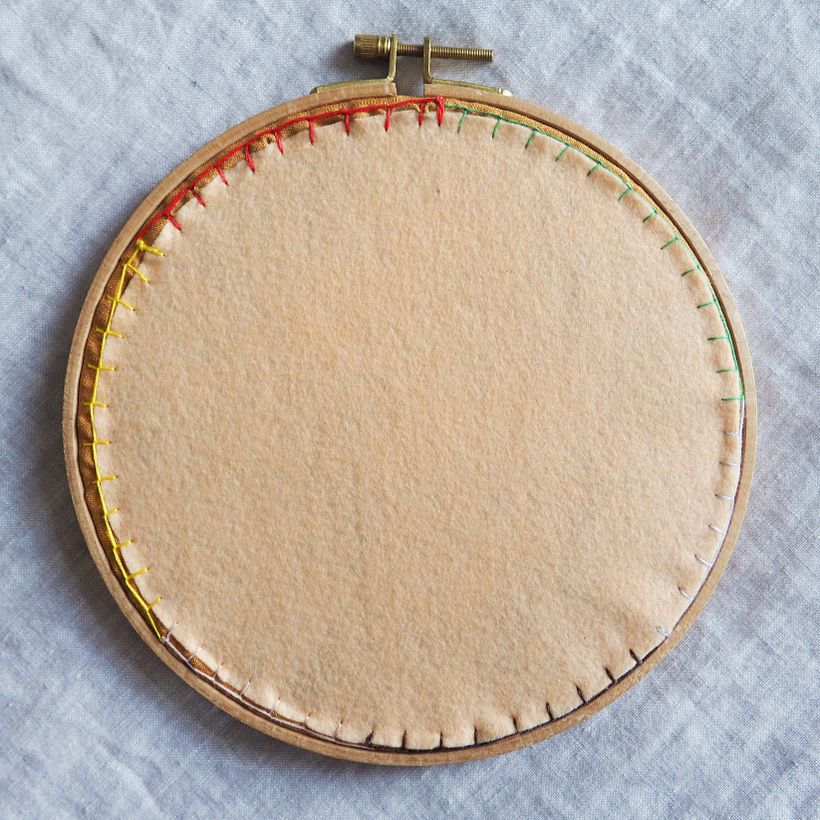 On the back I use leftover threads from this and other projects to create a blanket-stitched rainbow ring around the piece.