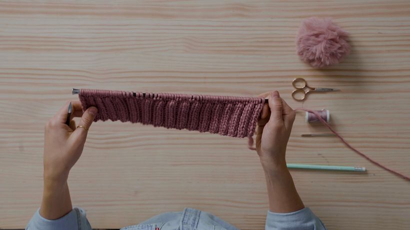 Teje 11 pasadas de puntos elásticos 2x2 para empezar a crear el cuerpo del gorro.