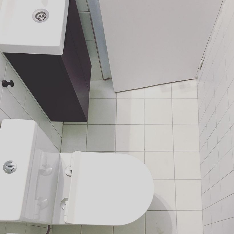 Suelo y paredes blancas con juntas grises que van de suelo a pared, creando un entramado perfecto.