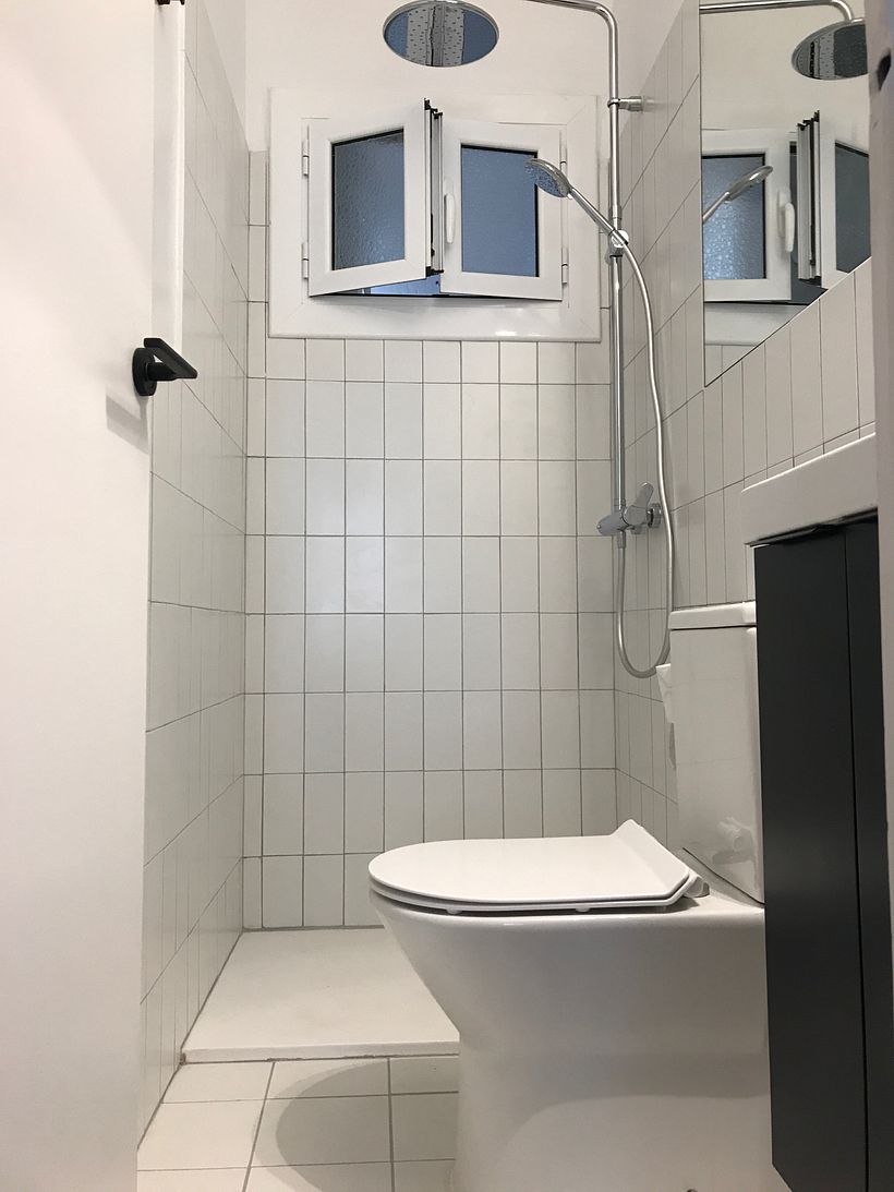 Baño pequeño con un gran espejo para darle más amplitud.