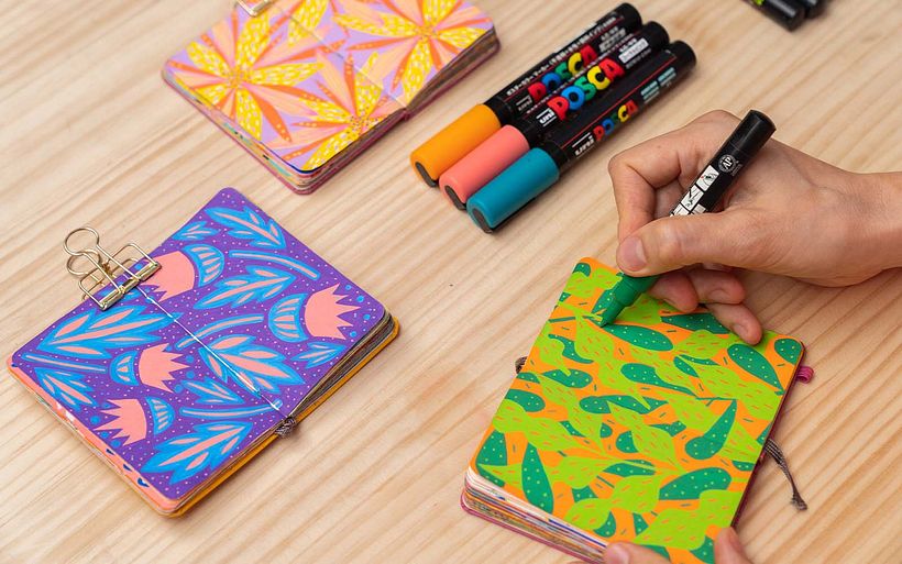 Polina montre les couleurs vives des stylos Posca dans ses carnets de croquis de poche.