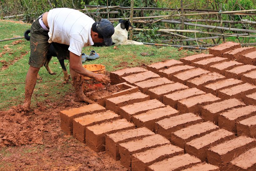 Laying up mud bricks to dry in the rural countryside. 