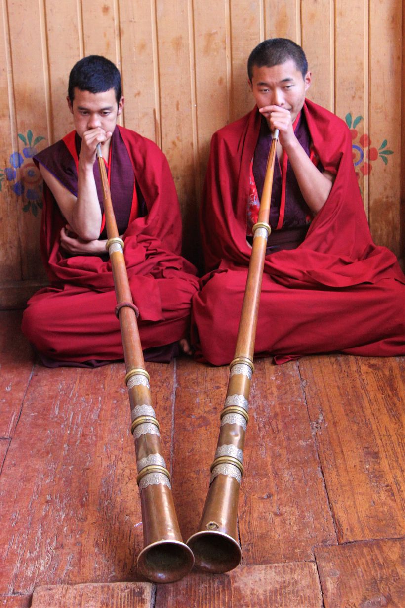 Playing dungchen, a traditionnal horn often used for Buddhist ceremonies. Its size can reach up to three meters.