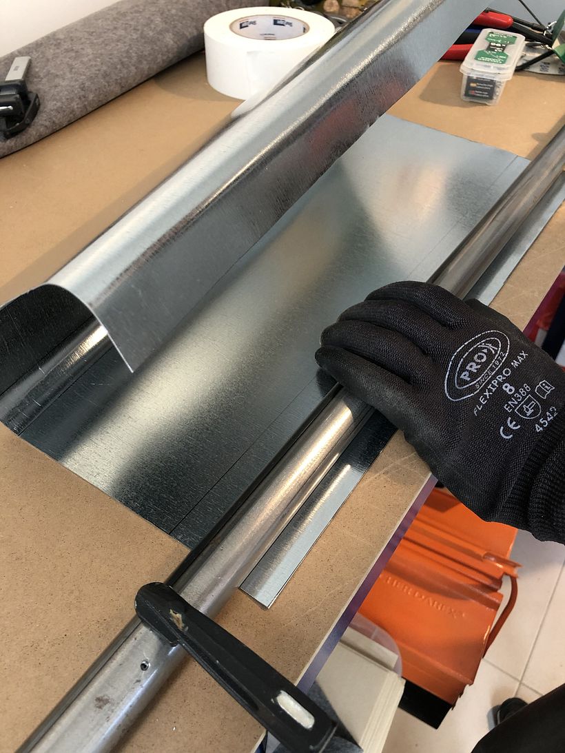 Un simple tube fixé à l'établi avec des serre-joints permet de plier la tôle.