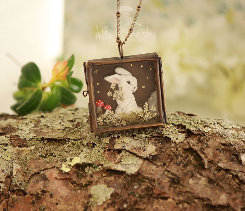 Pingente em forma de caixinha de metal com flores de cenoura preservadas e modelagens em cerâmica plástica