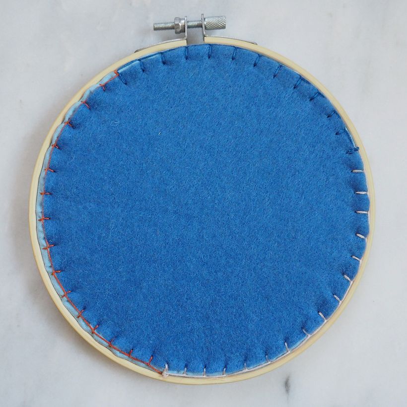 Blanket stitched wool felt as a backing using leftover threads from the piece.