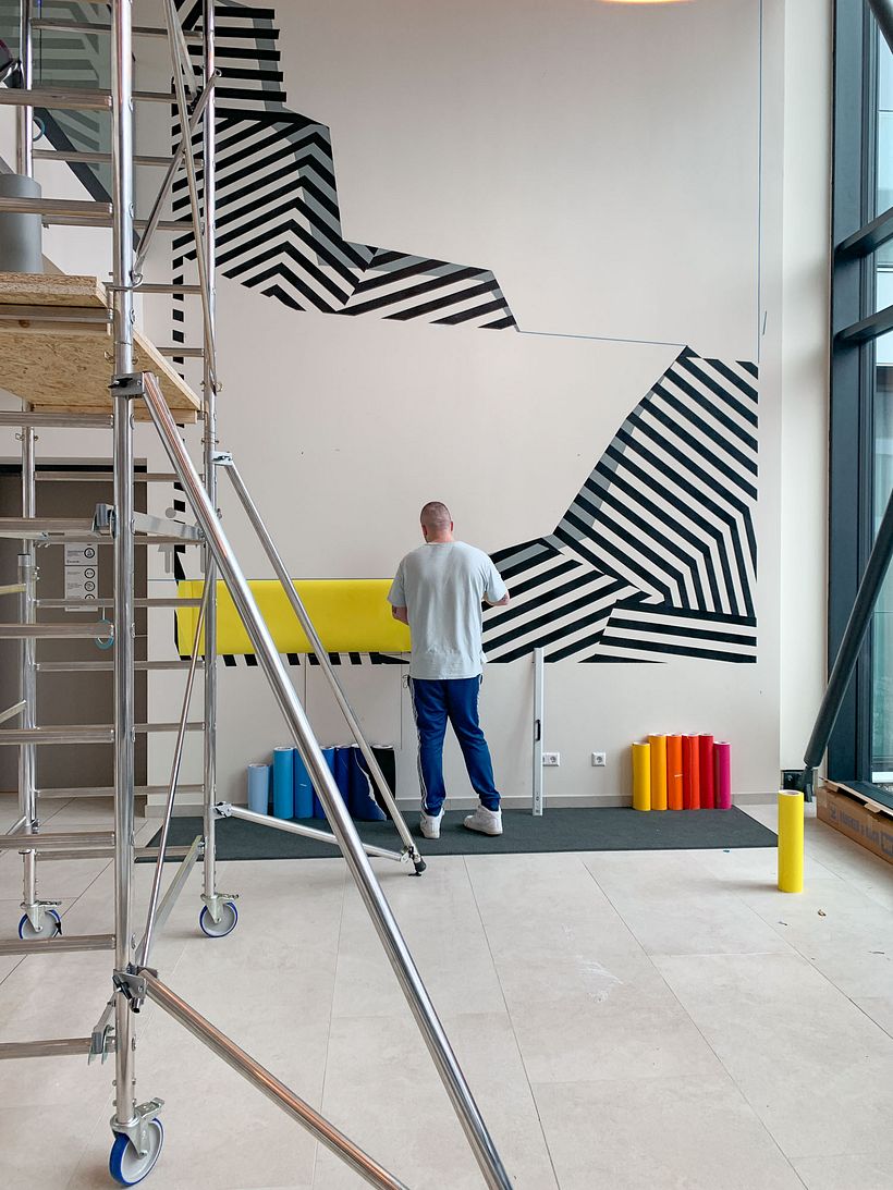 Nicolas Lawin taping a mural