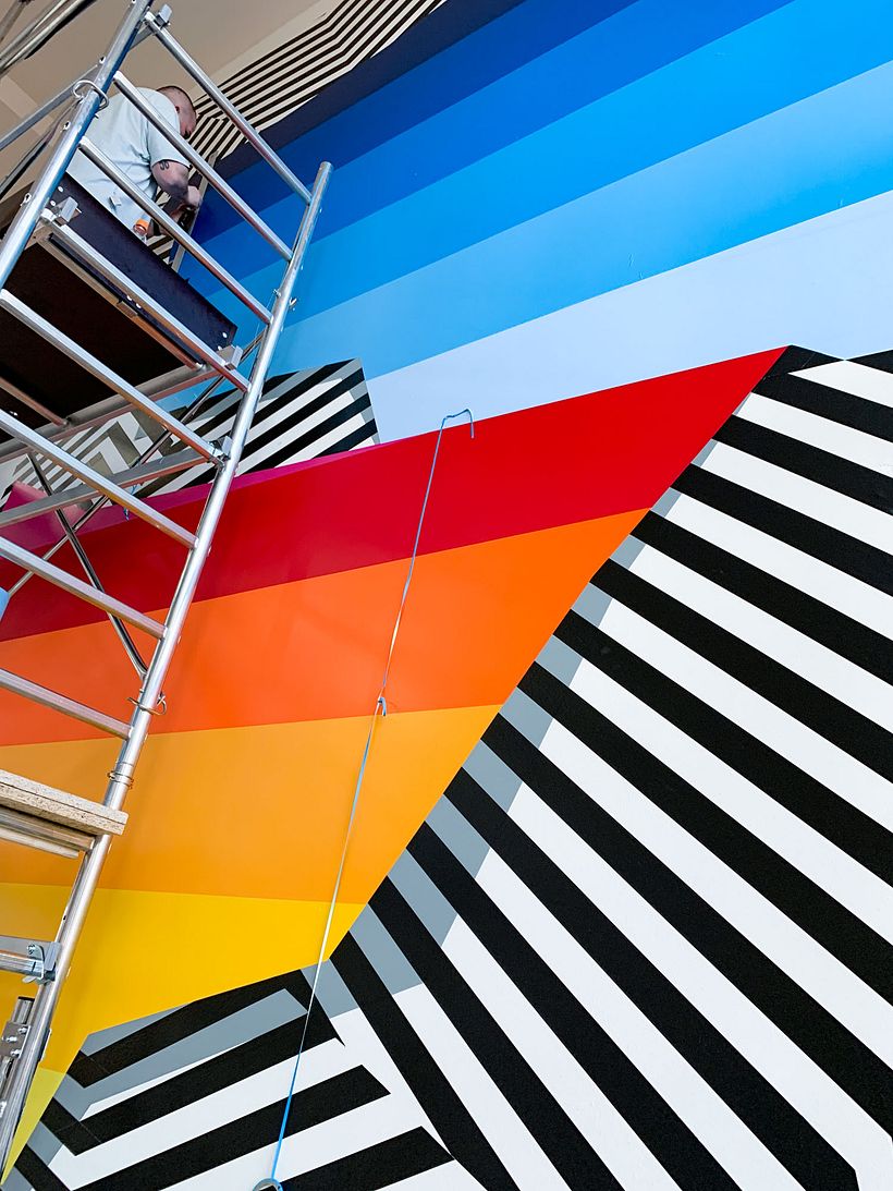 Nicolas Lawin taping a mural