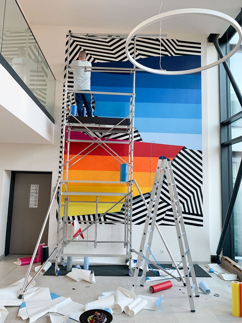 Nicolas Lawin taping a mural