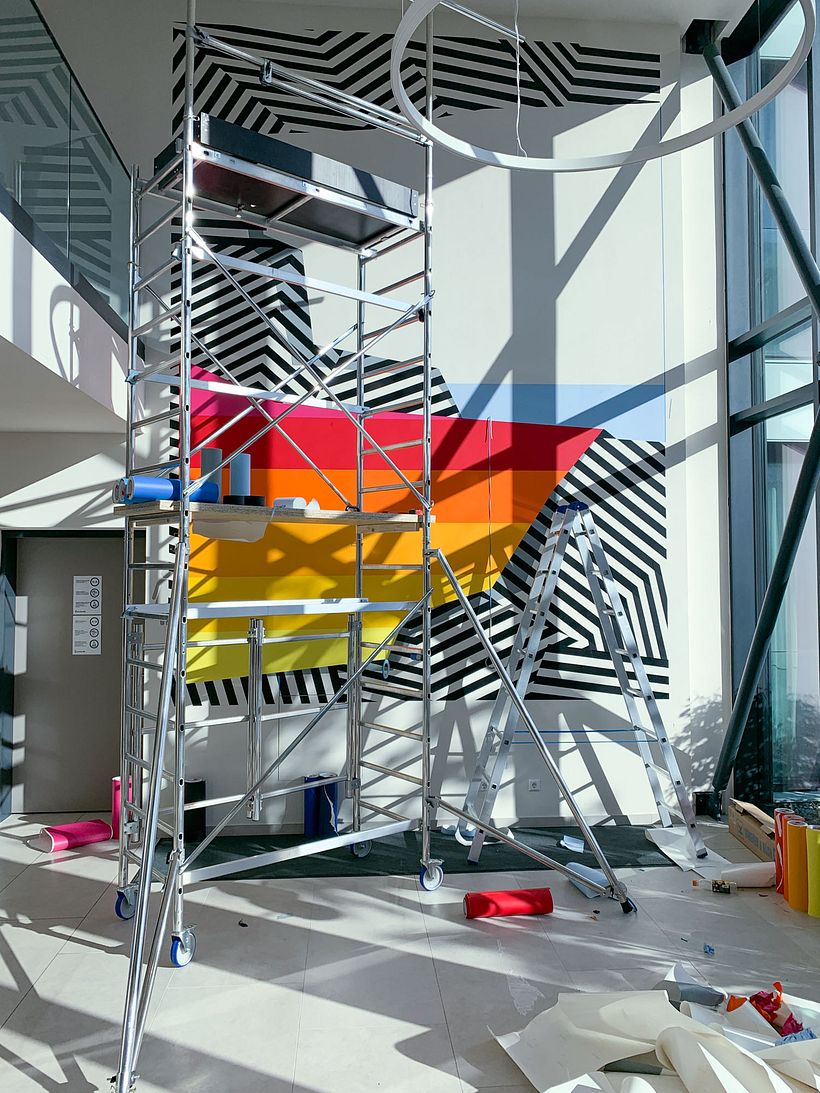 Nicolas Lawin taping a mural