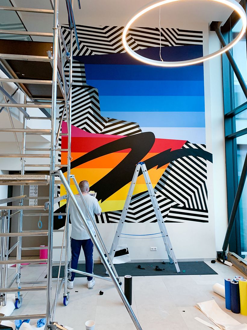 Nicolas Lawin taping a mural