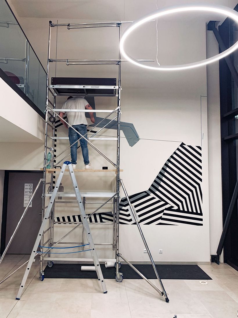 Nicolas Lawin taping a mural