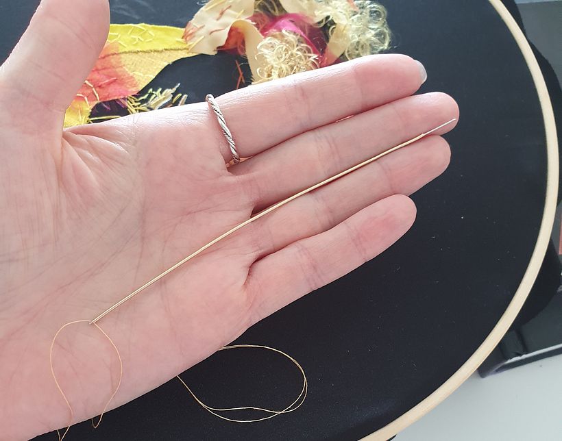 The needle with thread went through the long piece of french wire 