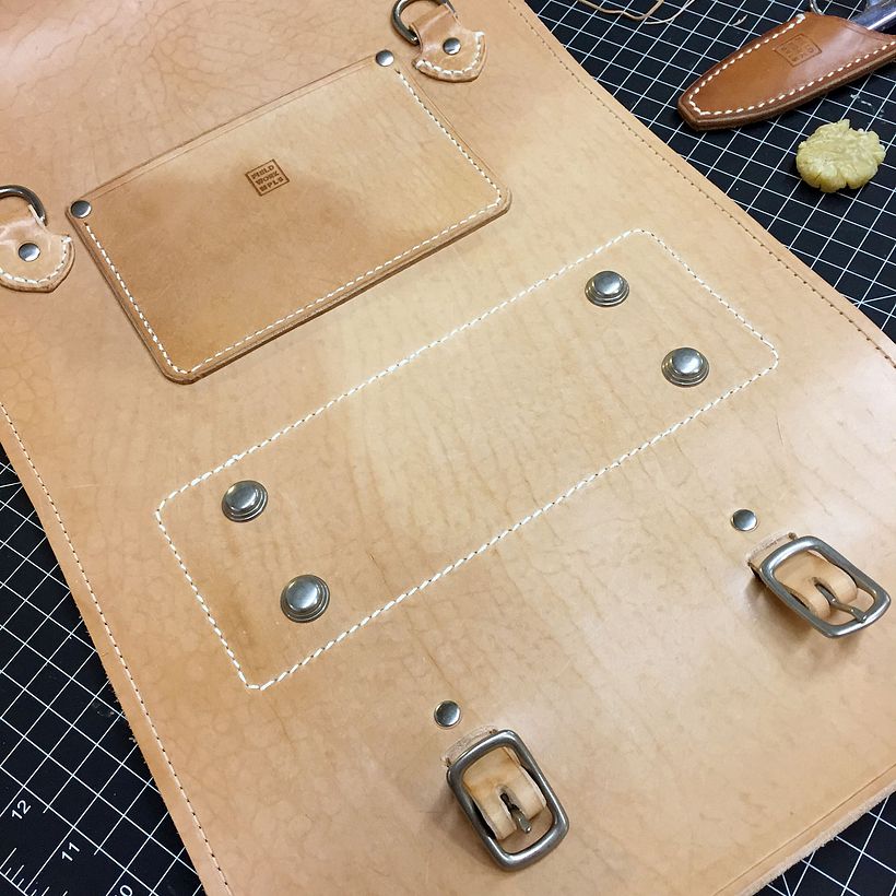 During the construction process. The vegetable tanned cowhide starts out quite pale and darkens over time.