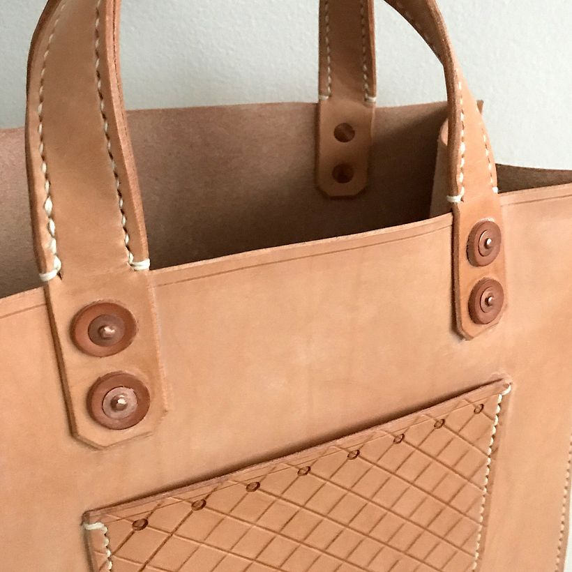 Close-up details of the pocket design, rivets, and handles