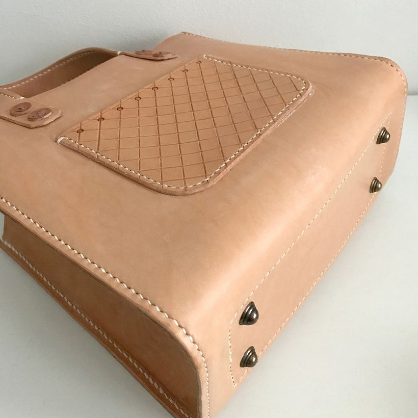 Sewn completely by hand and built to last. The brass feet add a nice touch.