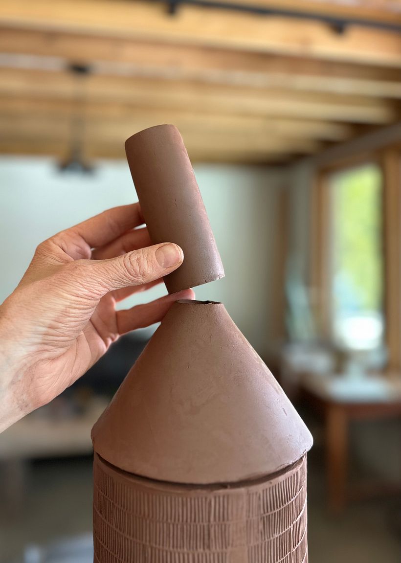 attaching the small cylinder to the top of the cone