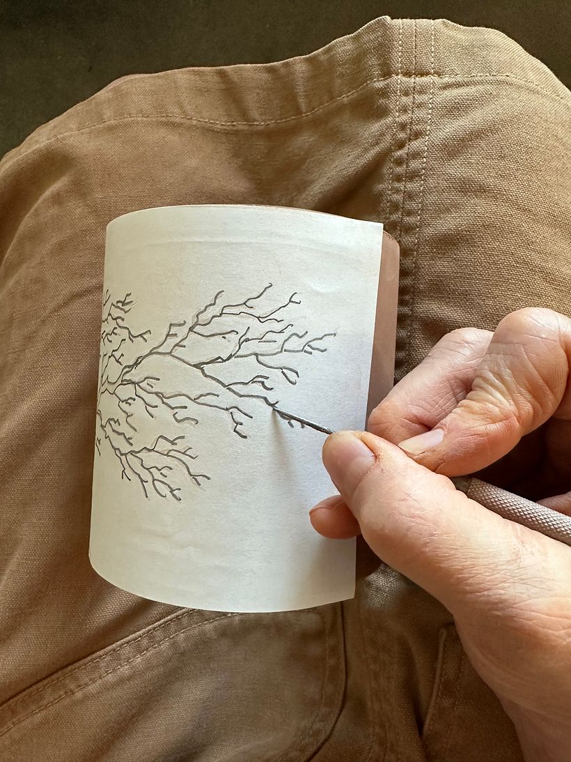 tracing the design onto the cylinder using a pin tool