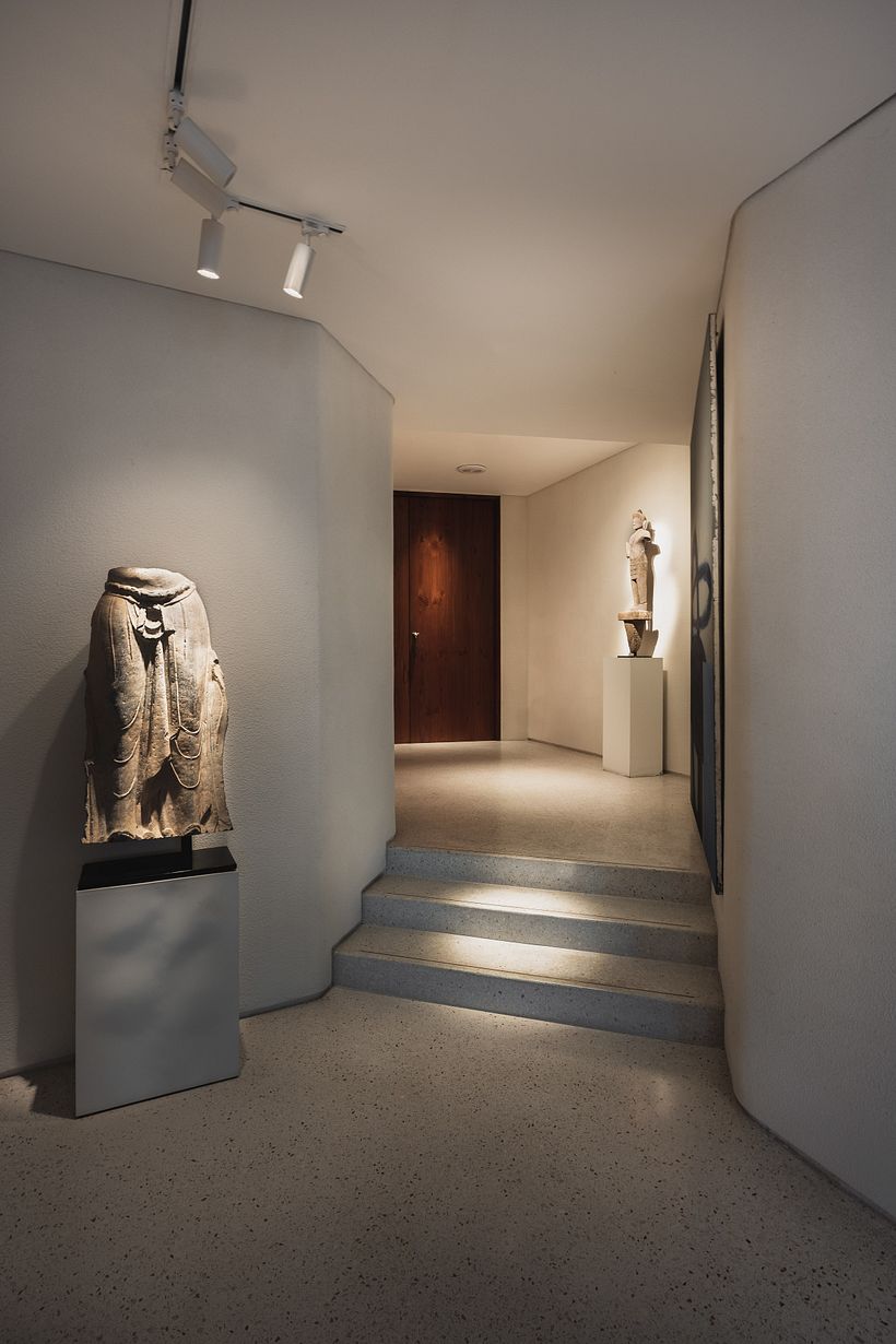 Entrance into the apartment with antique buddhas on plinth