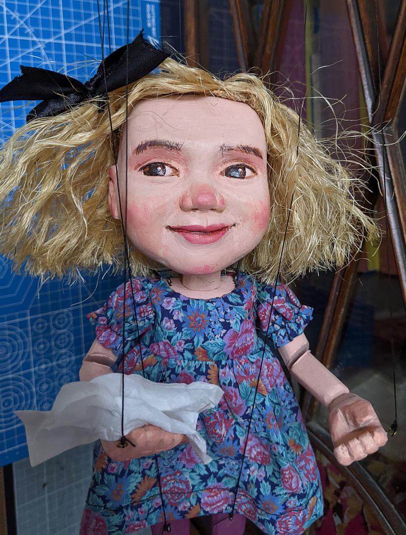 The puppet moves very well and is holding a tissue to blow her nose.
