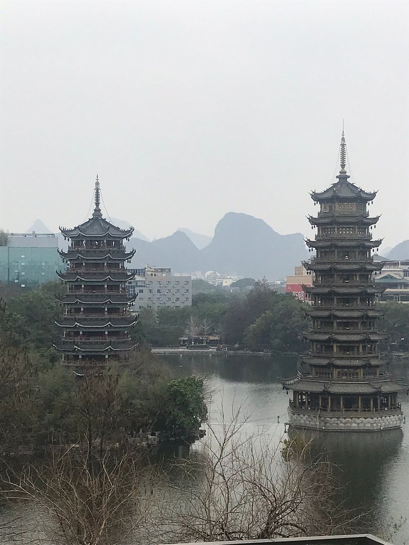 This is a scene in Guilin, China.  These towers are called "Sun and Moon Towers."