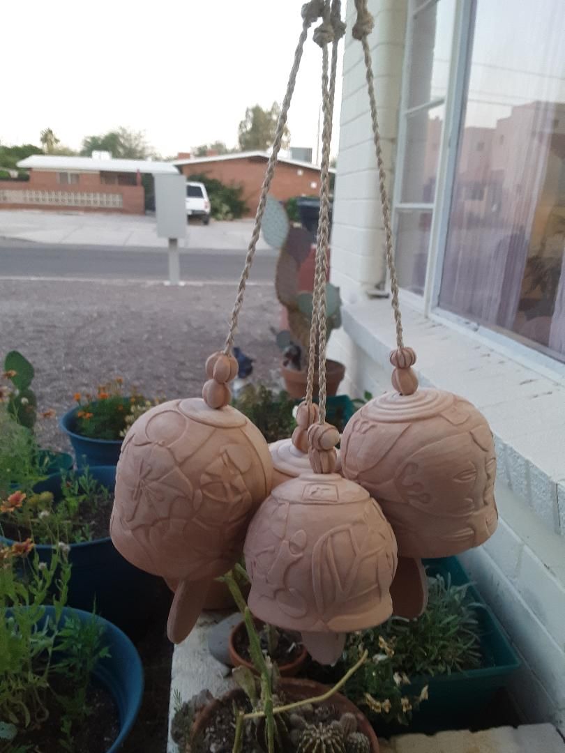Hand carved wheel thrown bells of wild clay I harvested and processed from the desert. The motif for each is a desert plant. 