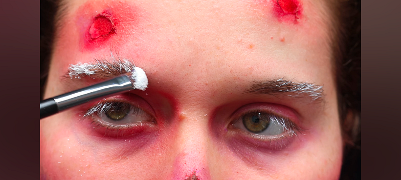 Adding powder to make it look like snow to the eyebrows.