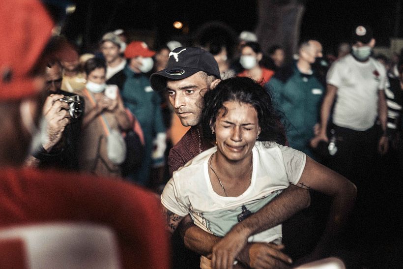 Un hombre sostiene a una mujer emocionada durante la misa