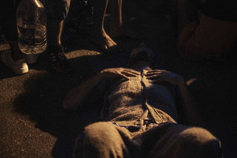 Un hombre acostado en el piso cansado luego de la peregrinacion
