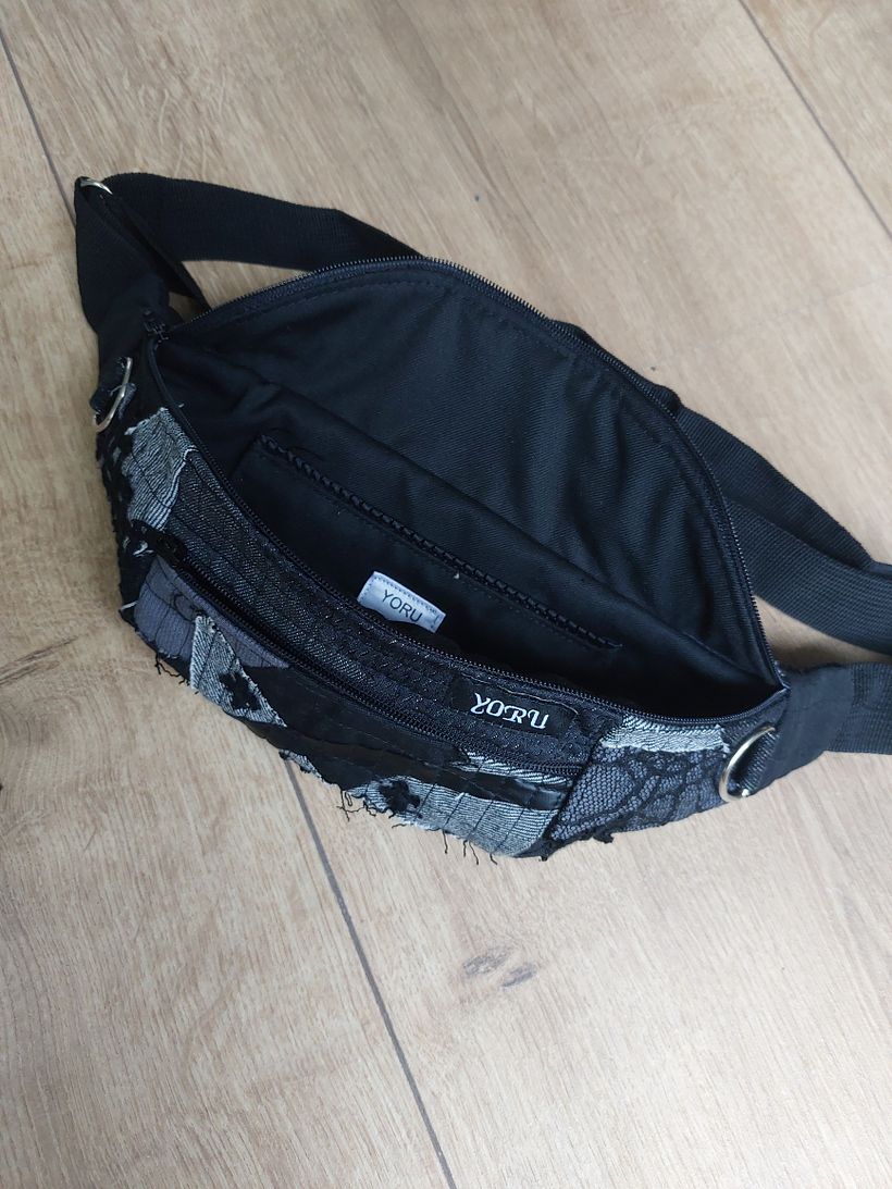 Showcasing the pockets inside the bag: lined front zipper pocket, stitched round pocket.