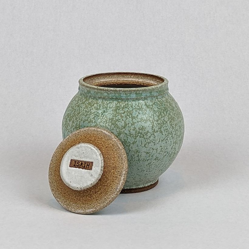 Round lidded jar in seafoam glaze. Lid propped up to show underside.
