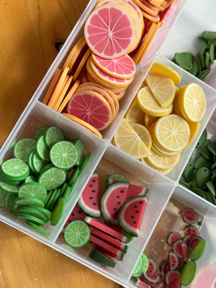 Fully baked polymer clay fruit pieces before they are varnished and made into earrings or magnets.