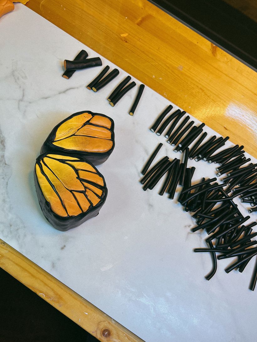 I made a skinner blend to create the inside color, cut and wrapped each section in black clay. Now the details!